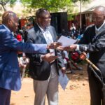 The two Cabinet Secretaries issuing cheques to several schools