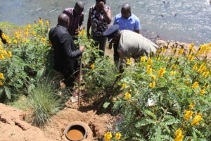 Laikipia East sub county commander John Tarus lifting an illicit brew tank with a stick at the Likii riverside on Thursday, June 8, 2023. About 760 litres of Kang’ara were destroyed.