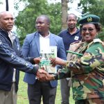 Deputy Chief Conservator Ms. Beatrice Mbula hands over a Participatory Forest Management Plan -2023-2027 to a member of Nyangores Community Forest Association (CFA)