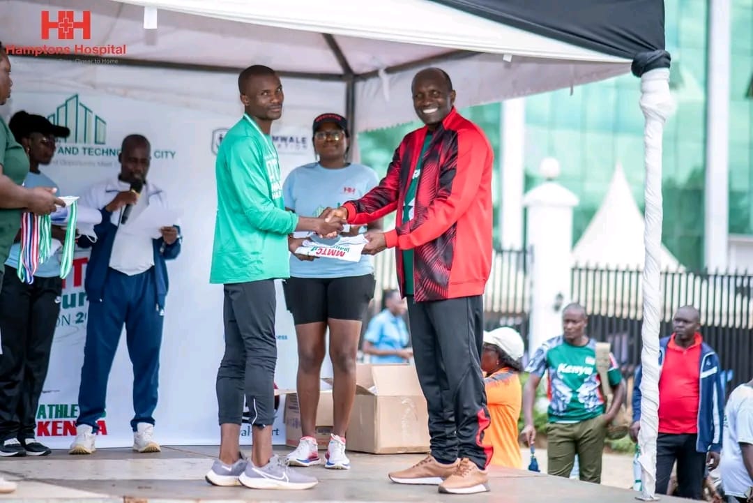 MMTC Founder Julius Mwale presenting a medal to one of the winners of the inaugural MMTC Marathon on Saturday, December 16, 2023.