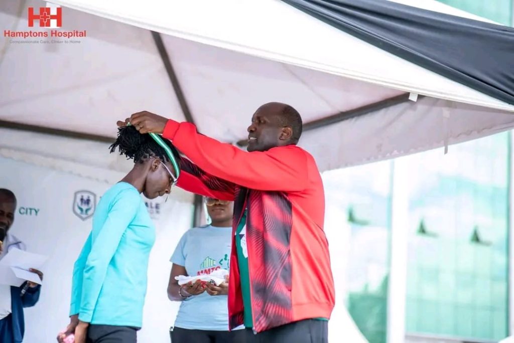 MMTC Founder Julius Mwale presenting a medal to one of the winners of the inaugural MMTC Marathon on Saturday, December 16, 2023.