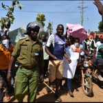 A security offices accompanies some of the protesters along Nkurumah road in Kisumu