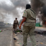 Mozambican security forces are seen next to a burning barricade in Maputo on December 24, 2024. Photo/AFP]