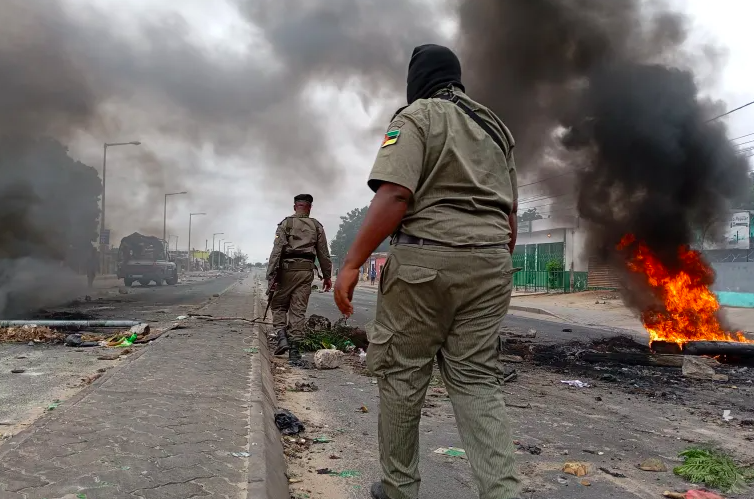 Mozambican security forces are seen next to a burning barricade in Maputo on December 24, 2024. Photo/AFP]